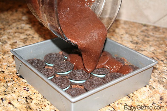 pouring brownie batter on cookies