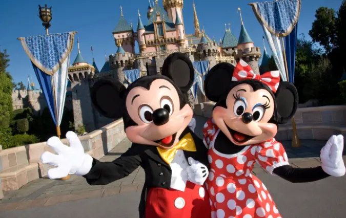 mickey and minnie mouse in front of castle