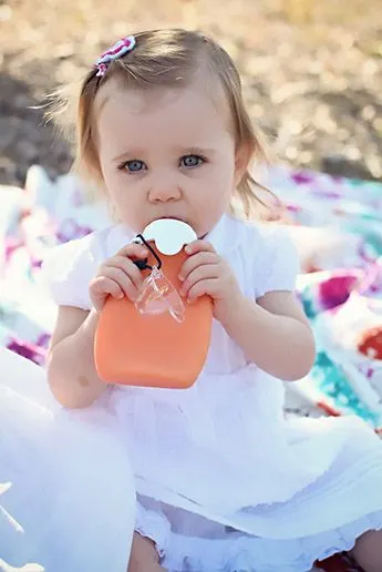 little girl drinking from a sili squeeze