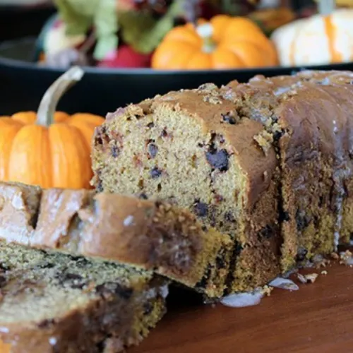 pumpkin bread with two slices cut on cutting board