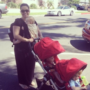 mom wearing baby and pushing stroller