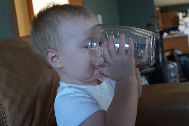 toddler drinking from a glass