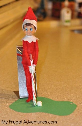 red elf golfing with candy cane