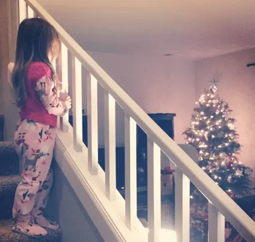 little girl looking at christmas tree