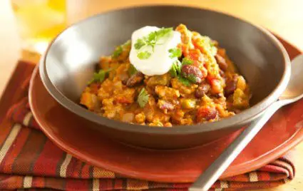 Pumpkin chili in a bowl with plate and spoon