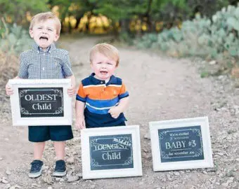 two little boys holding baby signs