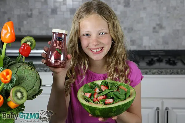 little girl holding strawberry dressing