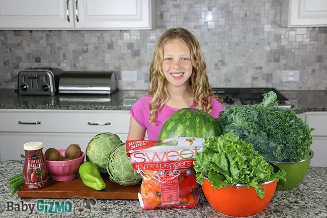 girl standing in front of counter produce