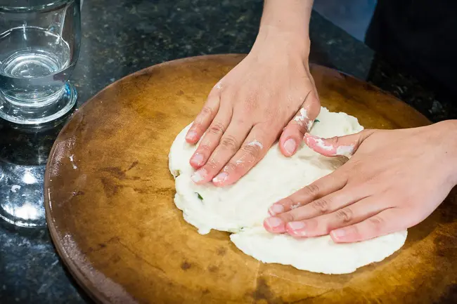 spreading naan dough