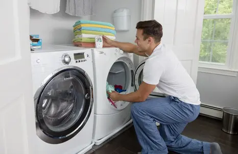 Dad checking the baby monitor while doing laundry