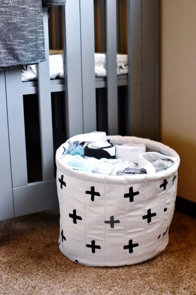 babyletto crib next to baby hamper