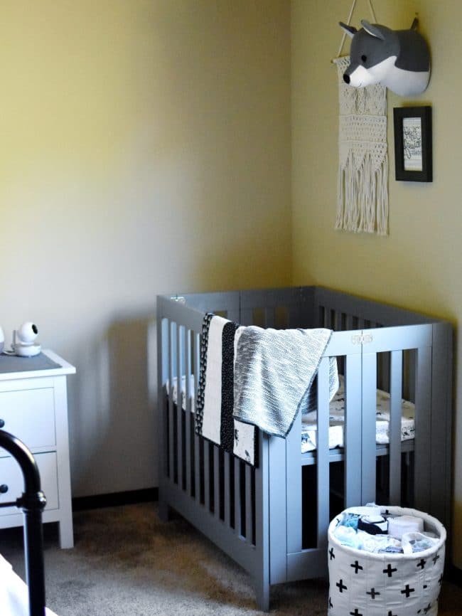 babyletto crib in corner of nursery in grey