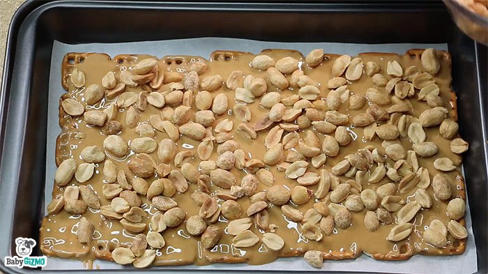 peanuts, peanut butter and pretzels in baking sheet