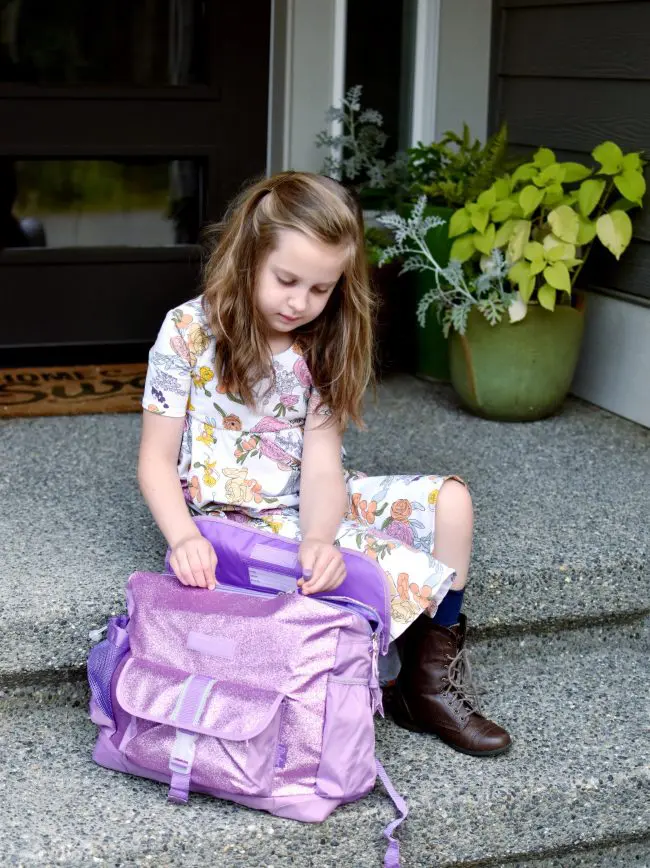 little girl sitting on stairs with bixbee backpack