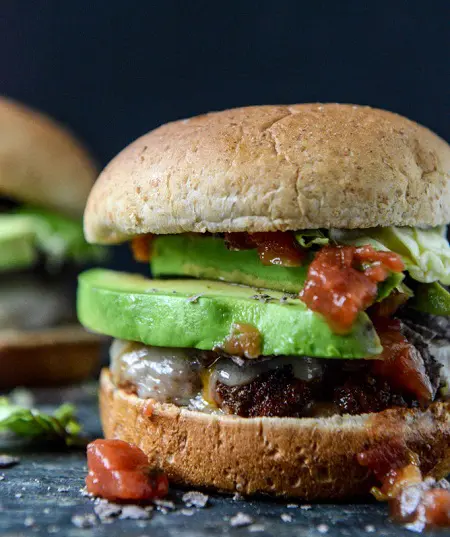 taco-rubbed burgers with avocado and crushed tortilla chips meal