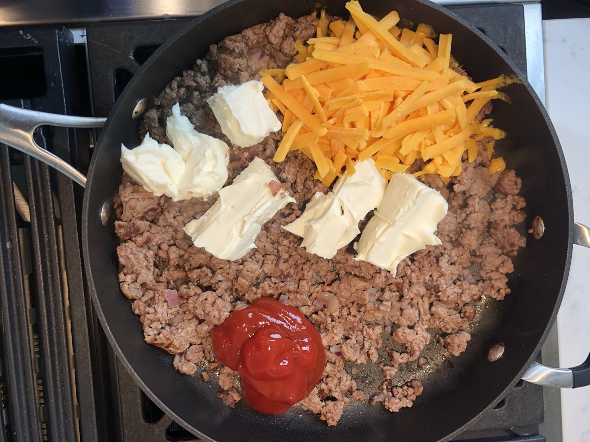 Cheeseburger ingredients in skillet