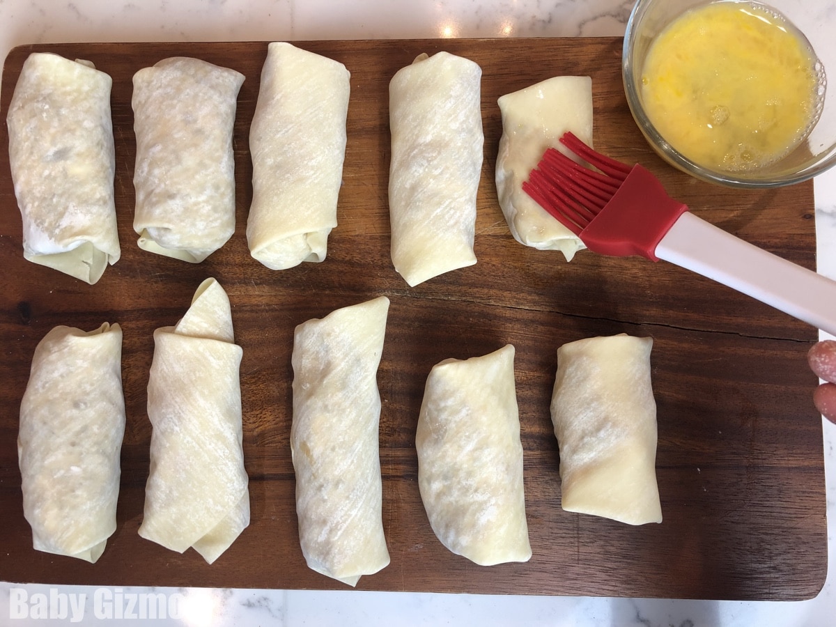 brushing eggrolls with egg wash