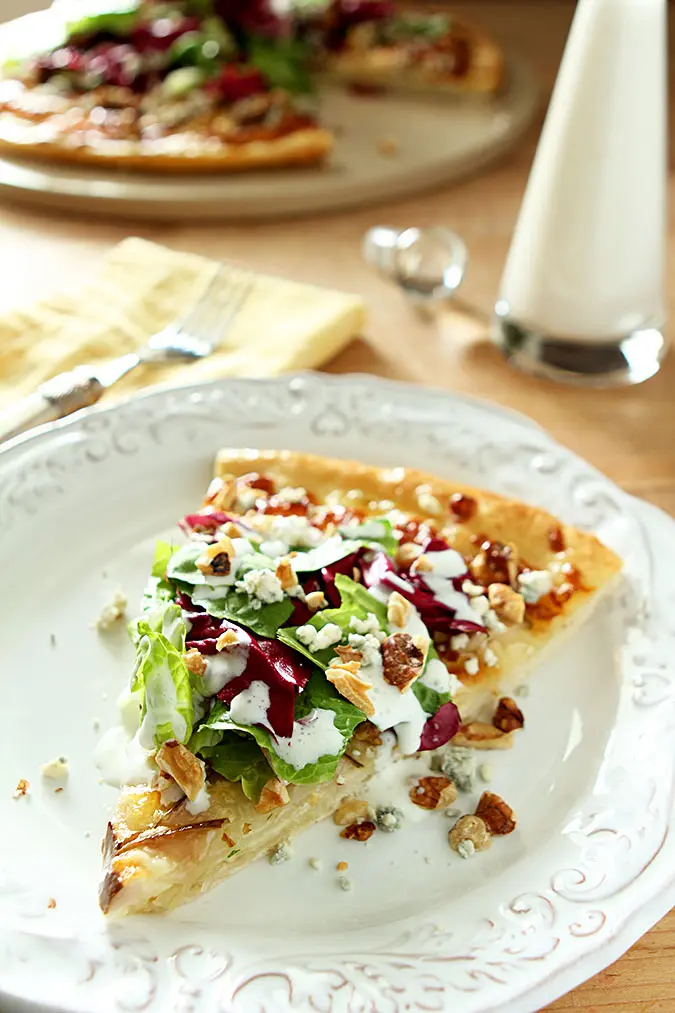 pear, gorgonzola and hazelnut pizza slice on white plate