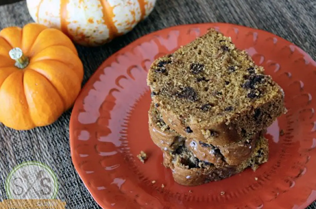 Three slices of pumpkin bread stacked on orange plate