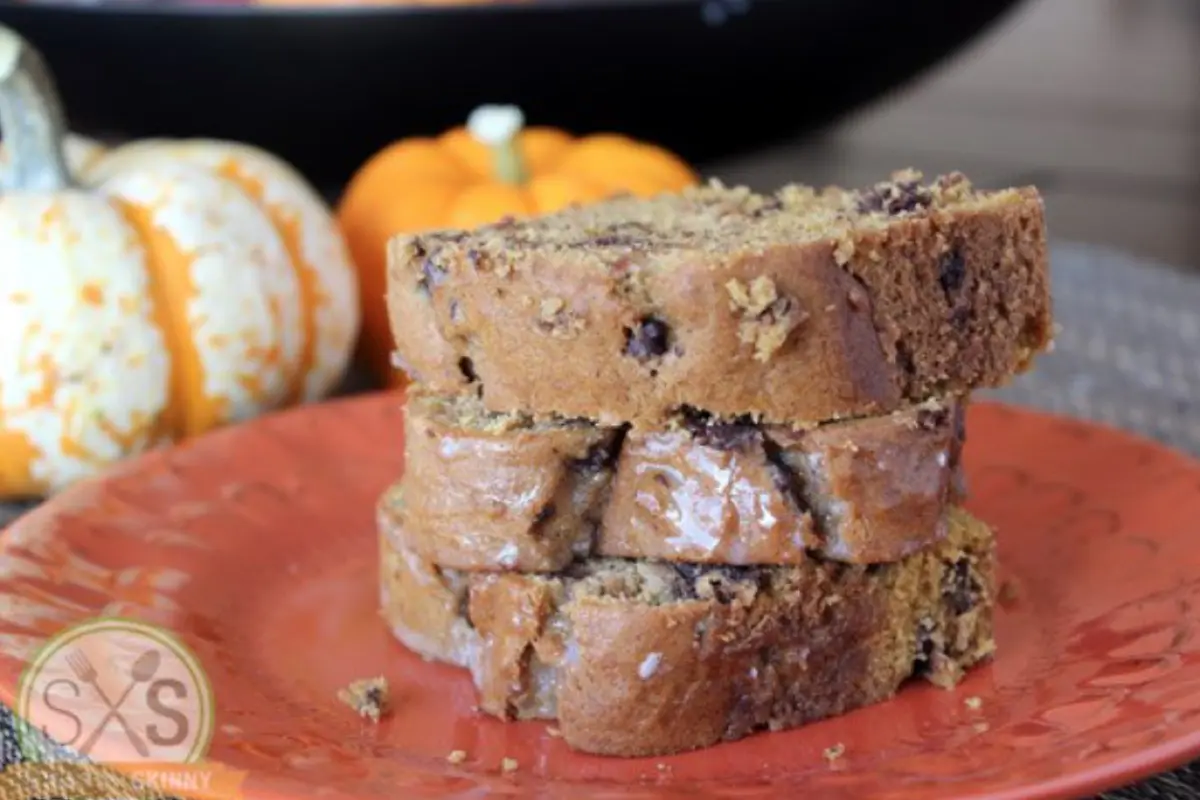 Three pieces of bread stacked next to pumpkins