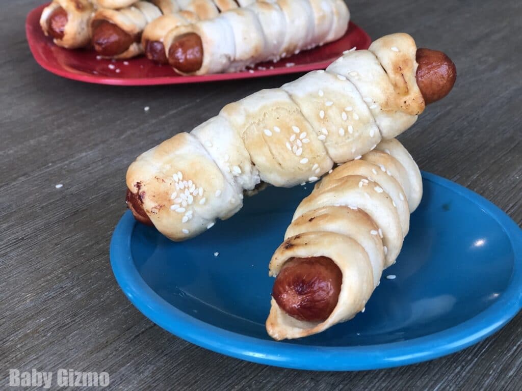 2 pretzel dogs stacked on blue plate