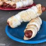 2 pretzel dogs stacked on blue plate