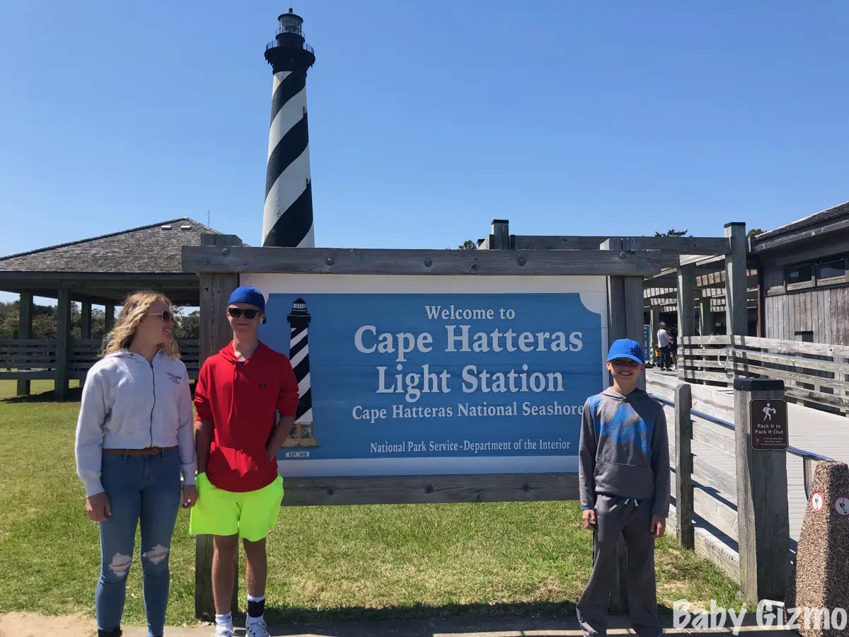 kids standing in front of cape hatteras light station sign