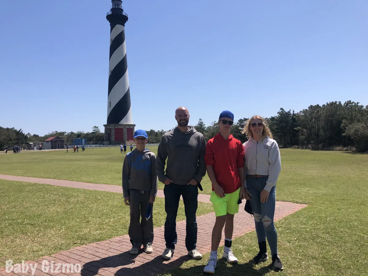 family standing in front of cape hatteras light house