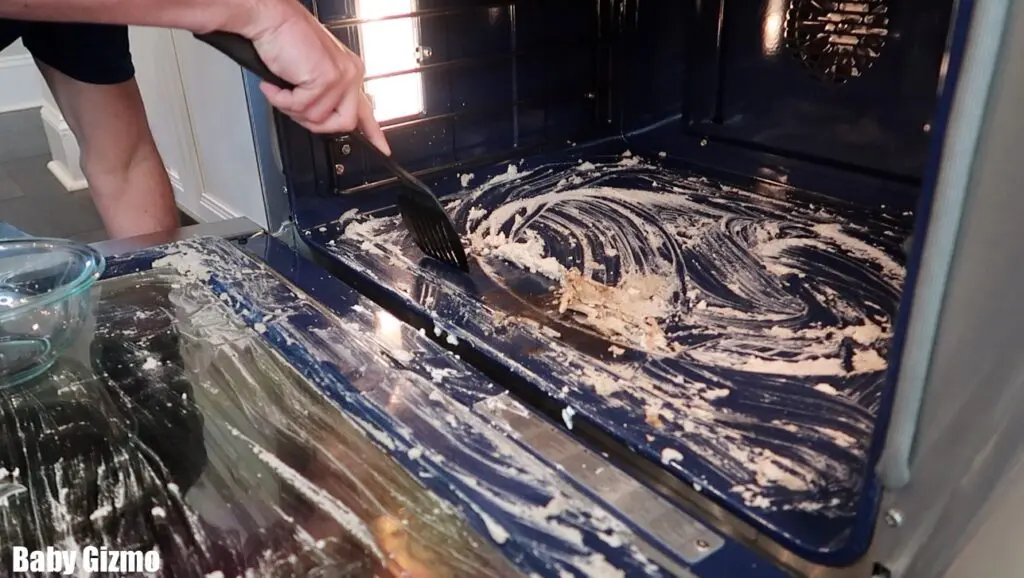 cleaning an oven with a spatula