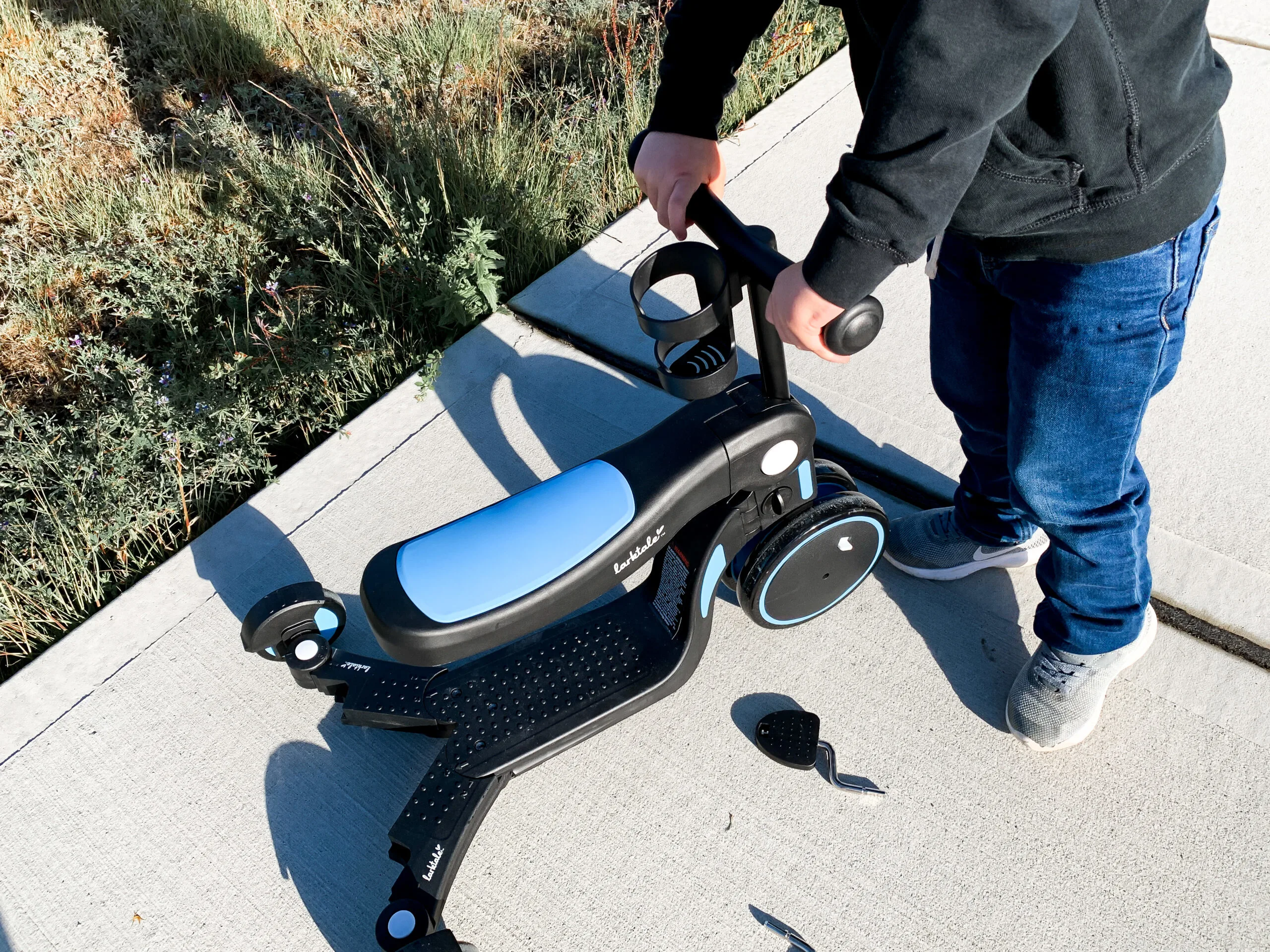 little boy with blue and black scoobi trike