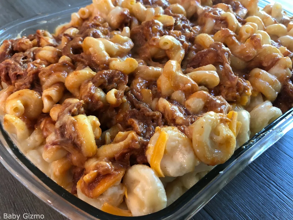 pulled pork mixed with homemade mac and cheese in a glass serving dish