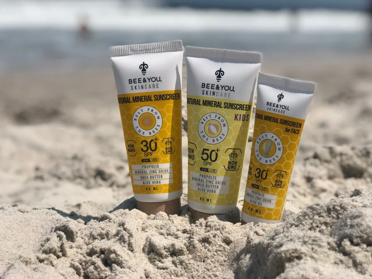 three bottles of natural sunscreen in the sand