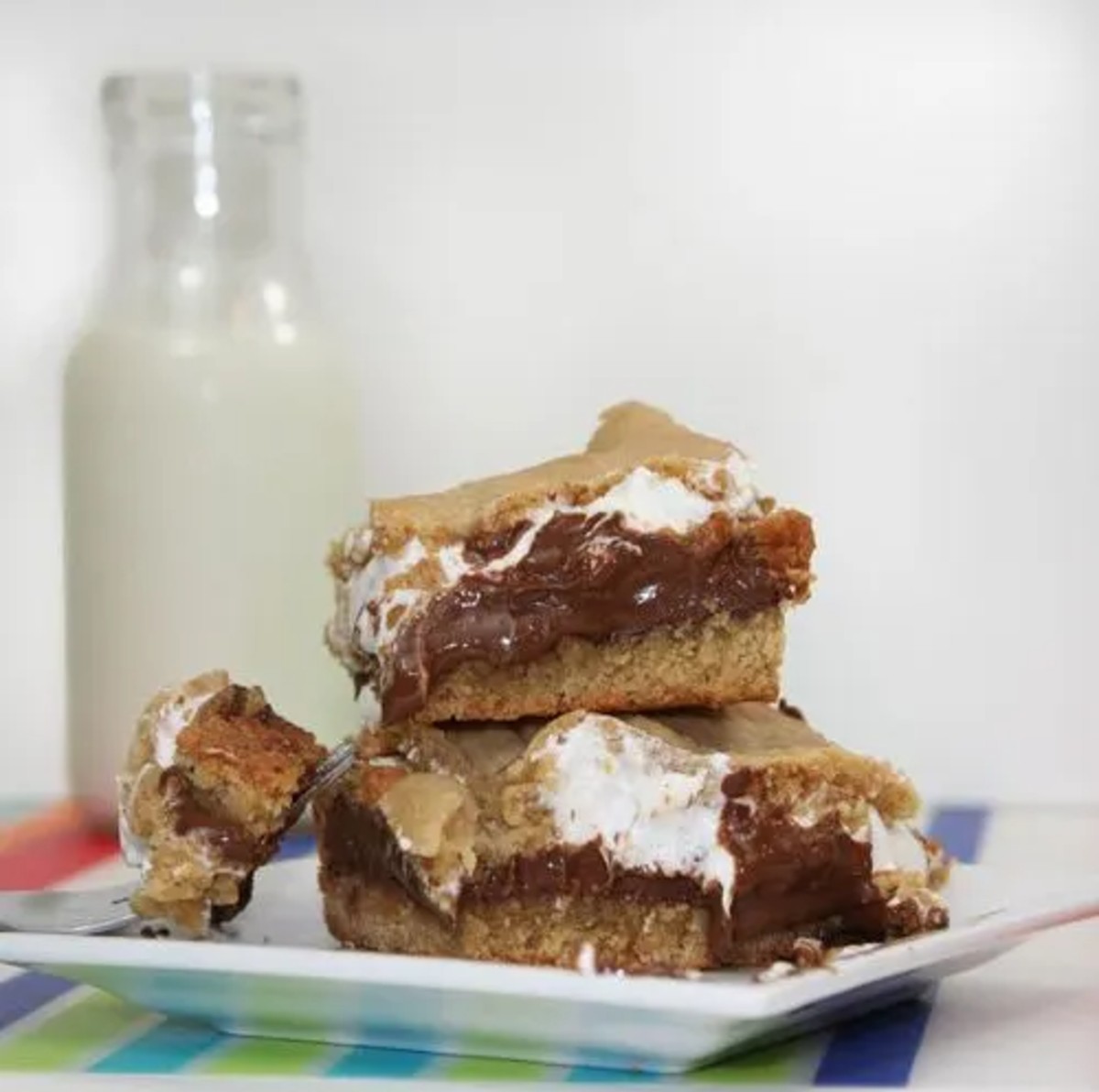 Peanut Butter S'mores Bars with milk in the background 