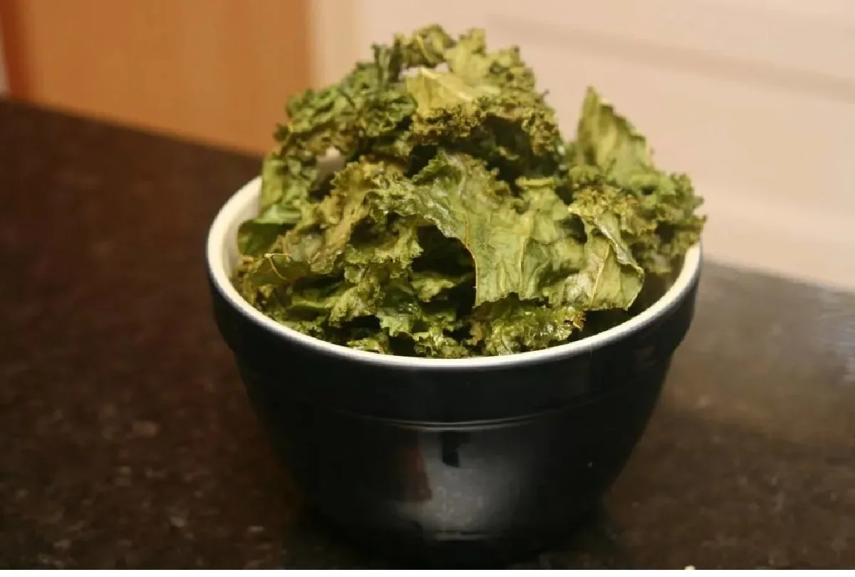 Lots of kale chips in a black bowl