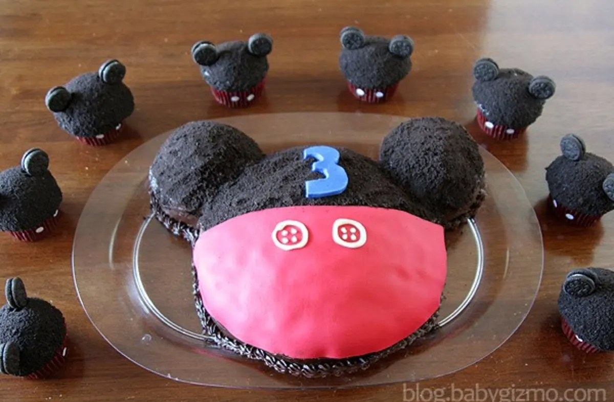Mickey mouse cake with little mini mickey cupcakes around it 